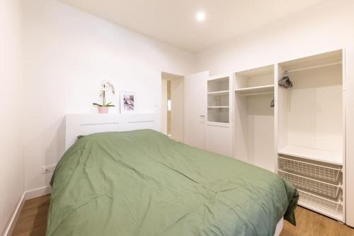 - une chambre avec un lit vert et des murs blancs dans l'établissement Le Nid Alsacien - Charmant T2 au centre ville de Strasbourg, à Strasbourg