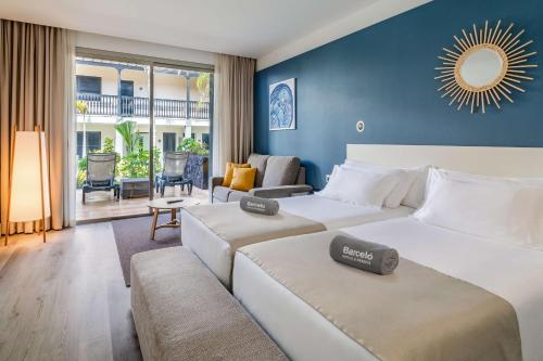 a bedroom with two beds and a living room at Barceló Fuerteventura Castillo in Caleta De Fuste