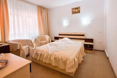 a hotel room with a bed and a window at Suior Resort Baza in Baia-Sprie