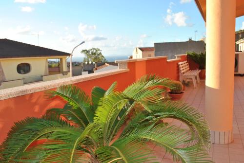 un balcón con palmeras y una pared de naranjos en La Terrazza sul Golfo, en Sennori