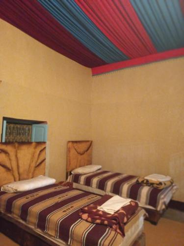 - 2 lits dans une chambre dotée d'un plafond coloré dans l'établissement Gite d étape Khettara Oasis, à Errachidia