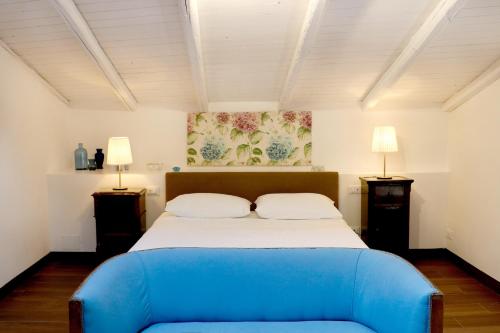 1 dormitorio con 1 cama azul grande y 2 lámparas en Agrirėlais Eremo Sant’Anna, en Valverde