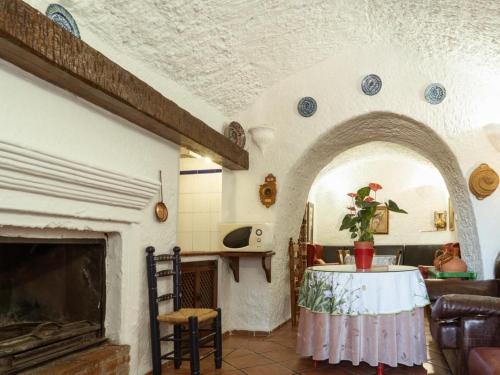 a living room with a table and a fireplace at Cuevas Pedro Antonio de Alarcon in Guadix