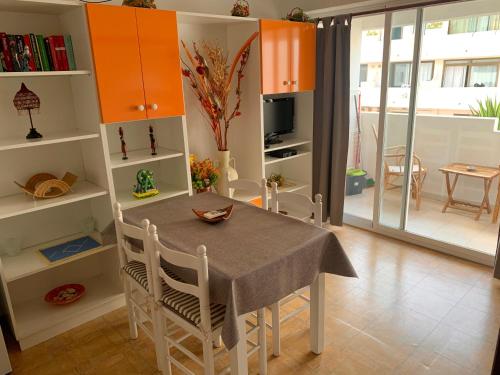 comedor con mesa, sillas y armarios naranjas en Apartments Yes, Es Pujols-Formentera vacaciones, en Es Pujols