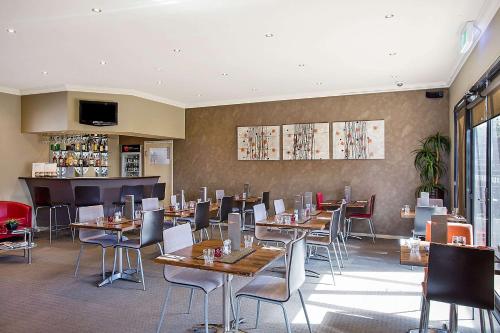 un restaurante con mesas y sillas en una habitación en Comfort Inn On Raglan, en Warrnambool