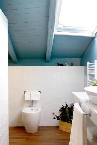 a bathroom with a white toilet and a sink at Agrirėlais Eremo Sant’Anna in Valverde