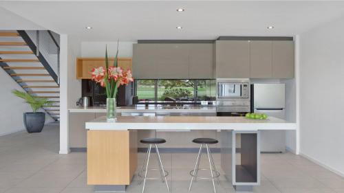 a kitchen with a white counter with stools in it at Magenta805 in Magenta
