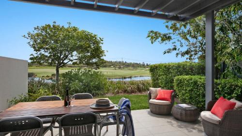 a patio with a table and chairs and a view of a golf course at Magenta805 in Magenta