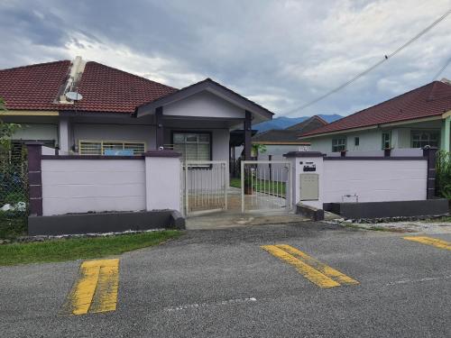 a house with a white gate and a white fence at KS Villa Homestay KKB in Kampong Peruntun