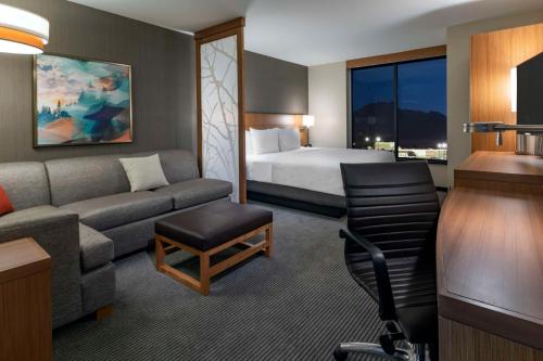 a hotel room with a bed and a couch at Hyatt Place Provo in Provo