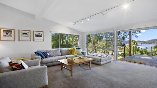 sala de estar con sofá y mesa en Bouddi Bush Retreat with Bay Views, en Booker Bay