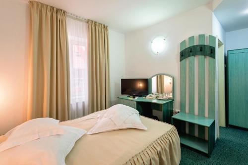 a bedroom with a bed and a vanity and a mirror at Suior Resort Baza in Baia-Sprie