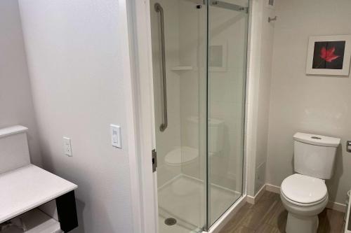 a bathroom with a toilet and a glass shower at Chateau Fredericton, Trademark Collection by Wyndham in Fredericton