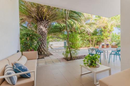sala de estar con sofá, mesas y un árbol en Villa Nami a 50mt dalla spiaggia, en Torre Santa Sabina