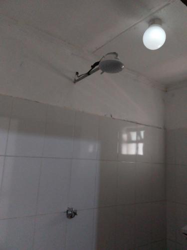 a bathroom with a white tiled ceiling and a light at White House Lounge Kot Nelel Guest House in Eldoret