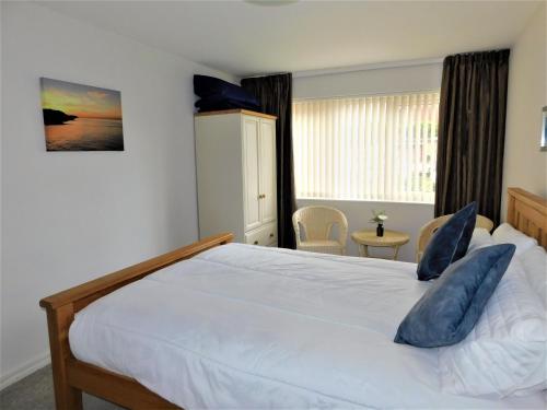10 Vista Court في شيرينغهام: غرفة نوم مع سرير أبيض كبير مع وسائد زرقاء