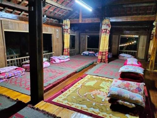 um quarto com três camas num quarto com um tapete em Homestay Chung Thúy em Ha Giang