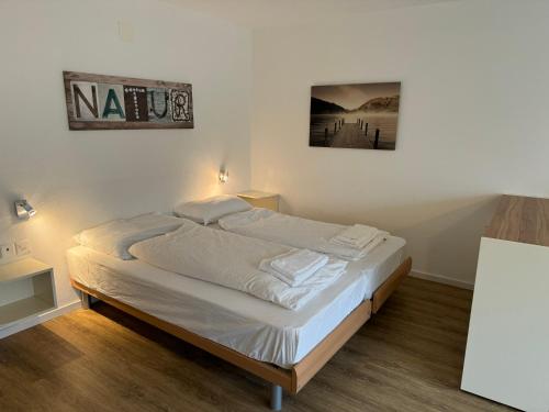 Bett in einem Zimmer mit einem Bild an der Wand in der Unterkunft Beautiful Cozy Studio Davos in Davos