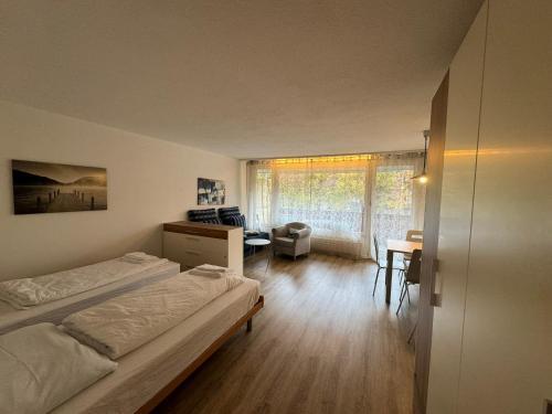 - une chambre avec deux lits, un bureau et une chaise dans l'établissement Beautiful Cozy Studio Davos, à Davos