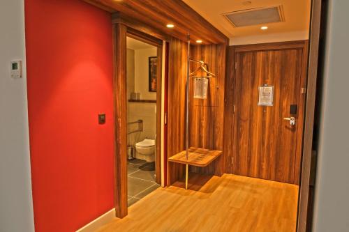 a bathroom with a toilet and a red wall at Hampton By Hilton Sakarya in Sakarya