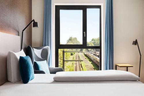a hotel room with a bed and a window at Vienna House by Wyndham MQ Kronberg in Kronberg im Taunus