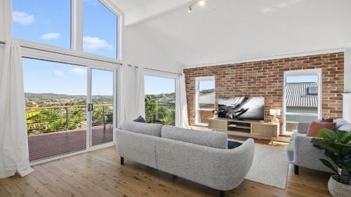 a living room with a couch and a tv and windows at Sea Crest at Copacabana in Copacabana