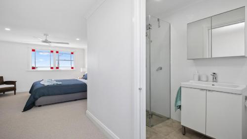 a white bedroom with a bed and a sink at Sea Crest at Copacabana in Copacabana