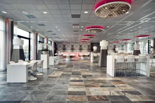 een opslagruimte met witte tafels en stoelen bij Mainport Hotel Rotterdam in Rotterdam