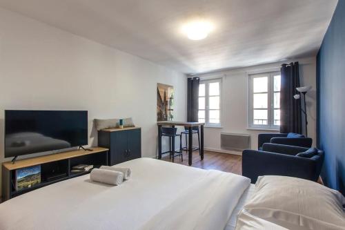 - une chambre avec un lit, une télévision et des chaises dans l'établissement Le 52 Zix - Joli studio au cœur de la Petite France, à Strasbourg
