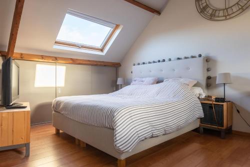 een slaapkamer met een groot bed en een dakraam bij Chez LyLy in Waver