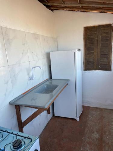 a kitchen with a white refrigerator and a stove at Casa Marina in Camocim