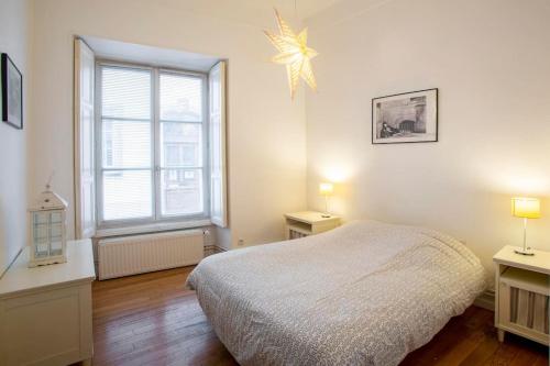 une chambre avec un lit et une grande fenêtre dans l'établissement Schlofa - Appt moderne dans Strasbourg, à Strasbourg