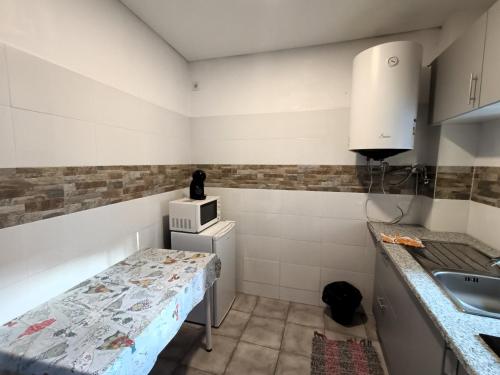 a small kitchen with a table and a sink at Bonjoia Apartments in Porto