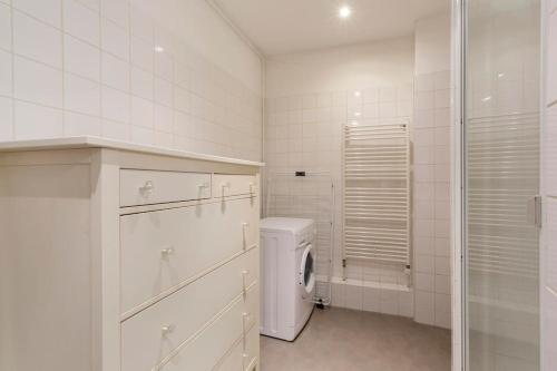 une salle de bain blanche avec une machine à laver à l'intérieur dans l'établissement Schlofa - Appt moderne dans Strasbourg, à Strasbourg