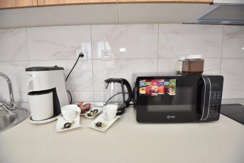 a kitchen counter with a coffee maker and a microwave at Apartman 1 in Kragujevac