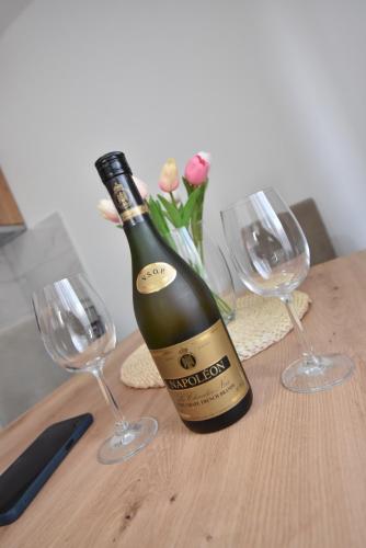 a bottle of wine sitting on a table with two glasses at Apartman 1 in Kragujevac