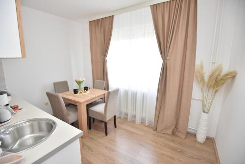 a kitchen with a table and chairs and a window at Apartman 1 in Kragujevac
