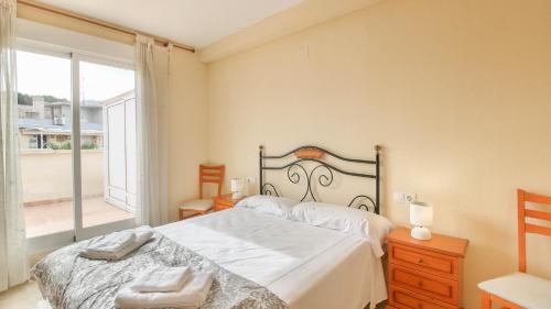 デニアにあるÁtico Puerta de Las Marinasのベッドルーム1室(ベッド1台、大きな窓付)