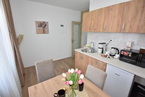 a kitchen with a wooden table with flowers on it at Apartman 1 in Kragujevac