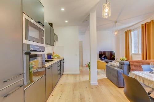 a kitchen and living room with a couch at Le Campels in Savignac-les-Ormeaux