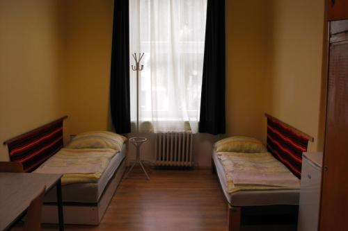 2 camas en una habitación con ventana en Mogyorodi Hostel, en Budapest
