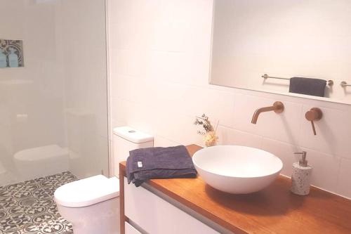 a white bathroom with a sink and a toilet at Evergreen Cabin in Primrose Sands