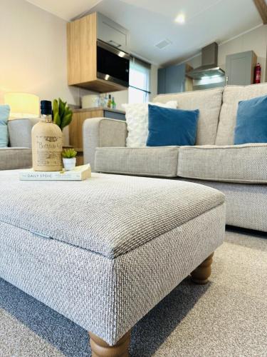 a living room with a couch and a ottoman at Beach Grove in Scarborough