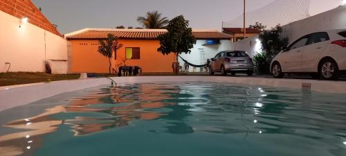 una piscina de agua frente a una casa en Chácara Corujá, en Juazeiro do Norte