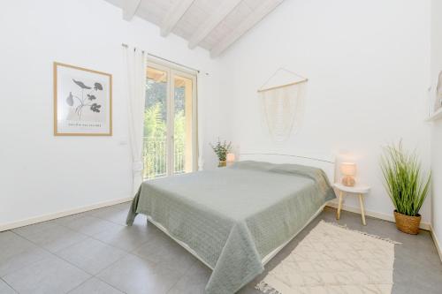 Habitación blanca con cama y ventana en Casa Verde, en Manerba del Garda