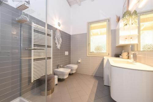 baño con 2 aseos y lavamanos en Casa Verde, en Manerba del Garda