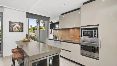 a kitchen with white cabinets and stainless steel appliances at Poolside at Magenta in Magenta