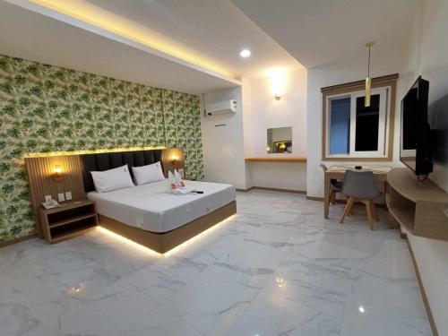 een slaapkamer met een groot wit bed en een bureau bij Honey Hotel - Balibago in Angeles