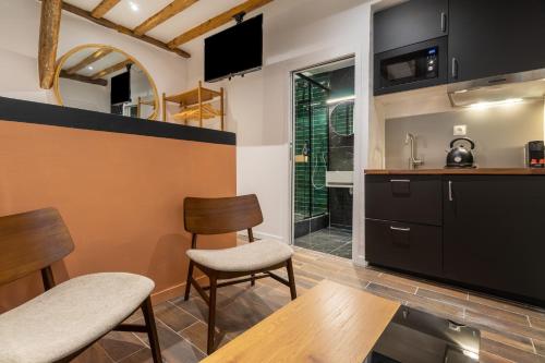 une cuisine avec une table, deux chaises et un comptoir dans l'établissement Luxe Marais Getaway - Suite Exclusive avec Sauna, à Paris