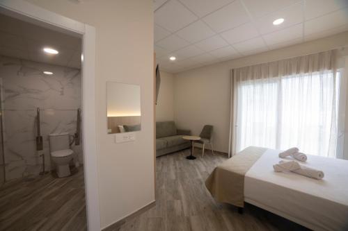 a hotel room with a bed and a bathroom at Hostal Altea Karma in Altea